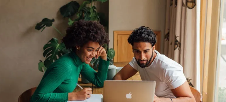 Two people using laptop to research interstate relocation mistakes to avoid