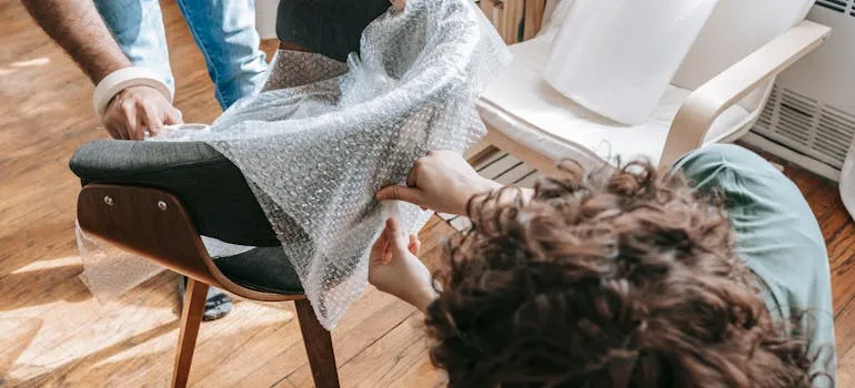 Two people packing a chair 