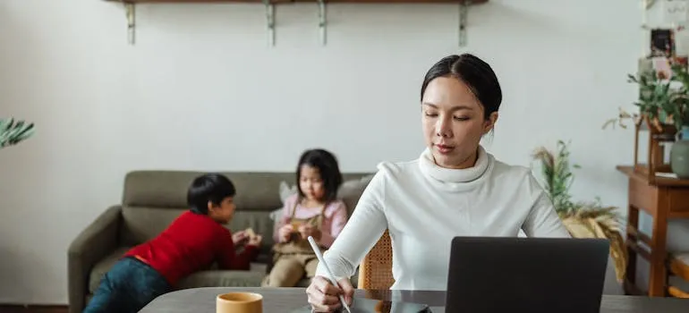 A woman with kids working from home in one of the places to live in the DMV for remote workers