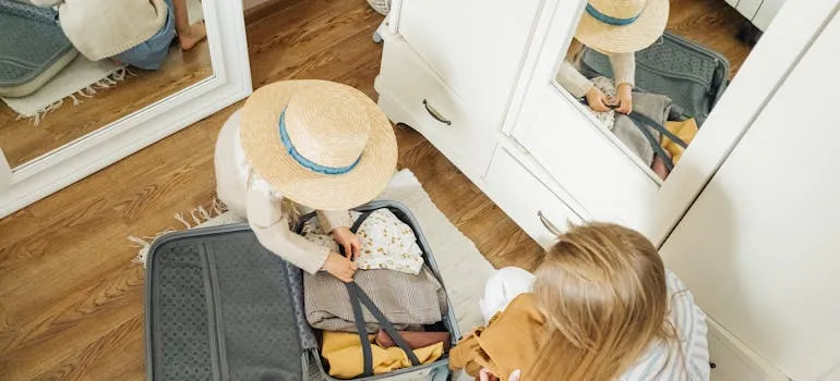 A woman and a kid packing y using a packing guide for relocating from DC to Miami
