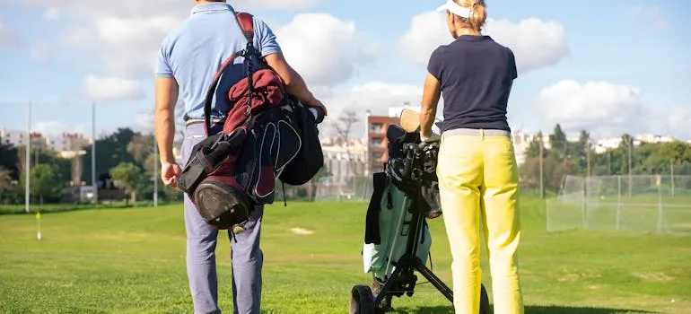 Two people playing golf and talking about affordable vs luxury living in Virginia