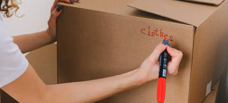 A woman labeling a moving box