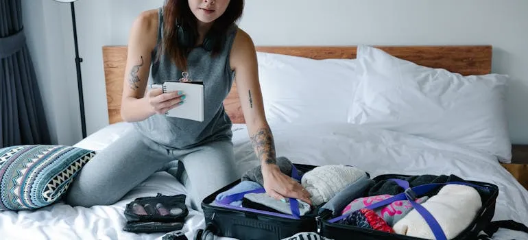 A woman packing and using checklist to downsize your home when moving from DC to LA
