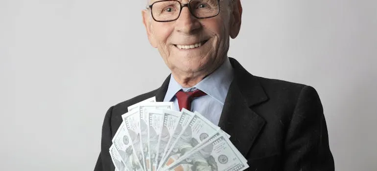 A senior holding dollar bills