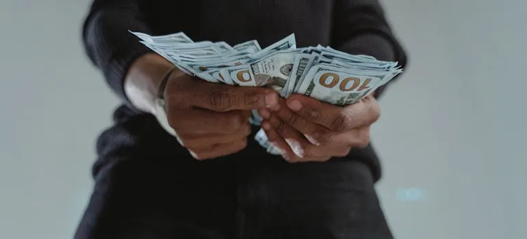 A person counting dollar bills and thinking how relocating from Maryland to North Carolina can improve your cost of living