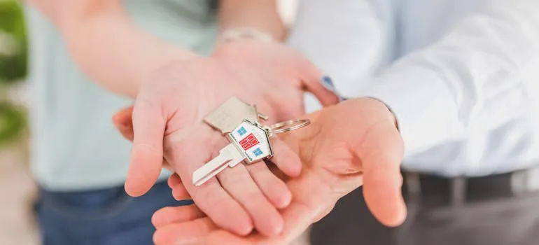 Two people holding a key
