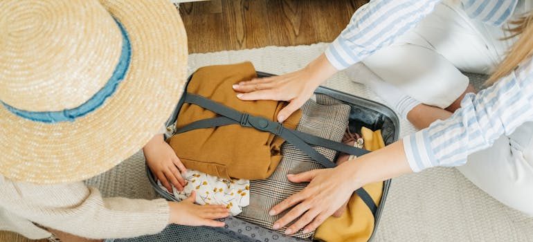 A person packing for moving from Virginia to warmer states