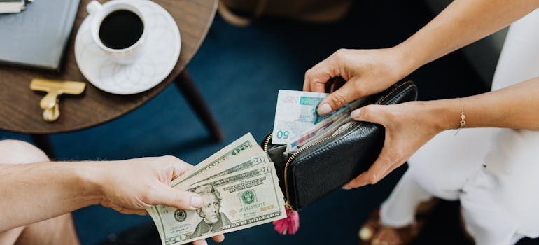 Two people counting money and talking about why Christmas is a surprisingly good time to relocate in the DMV