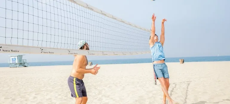 Two people playing valeyball on the beach