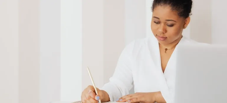 A woman writing in the notebook