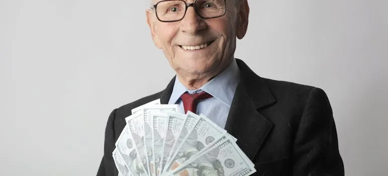 A senior holding dollar bills 