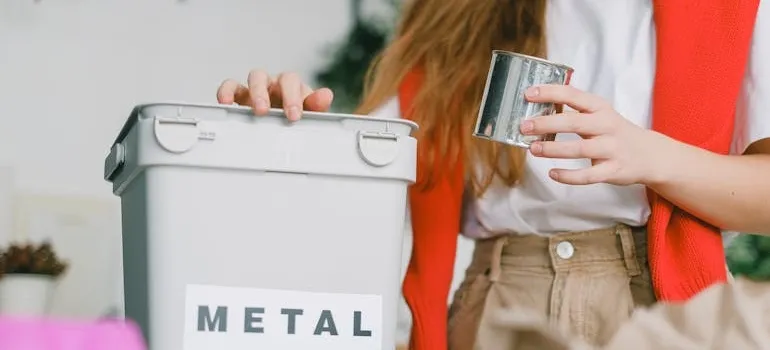 A woman using a bin in order to make your move eco friendly