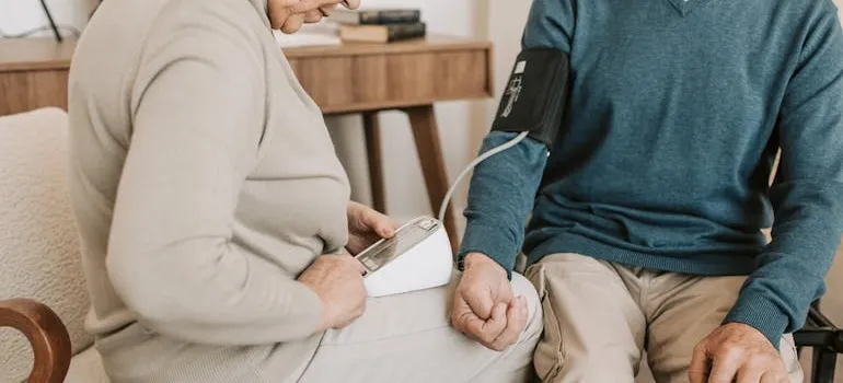 A woman checking a blood pressure to a man 