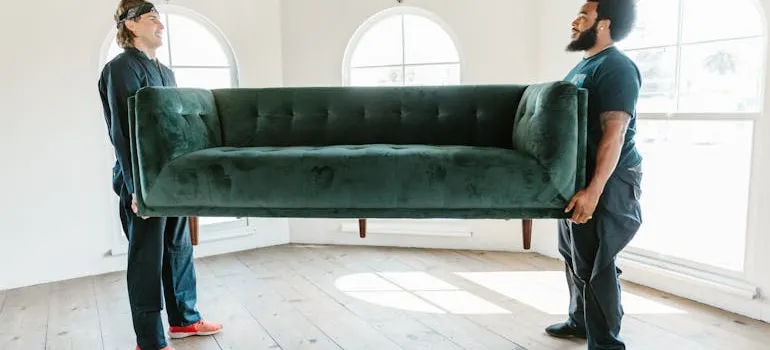 Two people carrying sofa