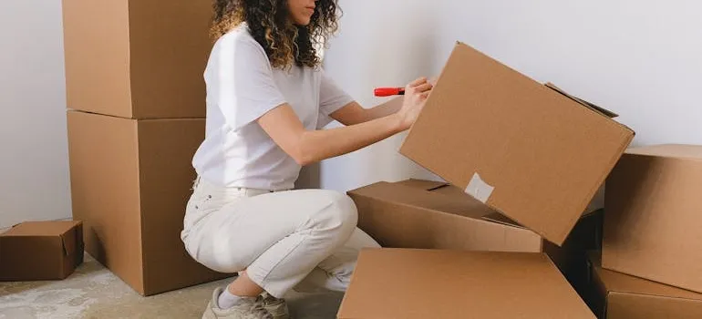 A woman labeling her moving boxes