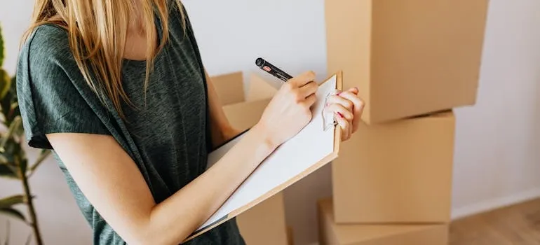 A woman writing a checklist for relocating from DC to LA