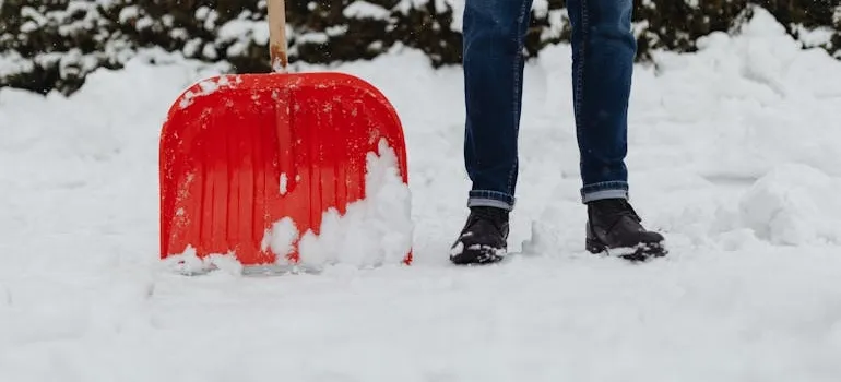 A person clearing driveway and thinking how weather in the DMV affects your move