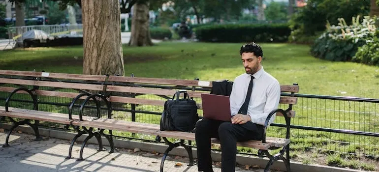 A man using a laptop to research industries to work in after moving from DC to NYC