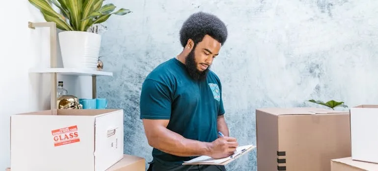A man packing while using a checklist for relocating from DC to LA