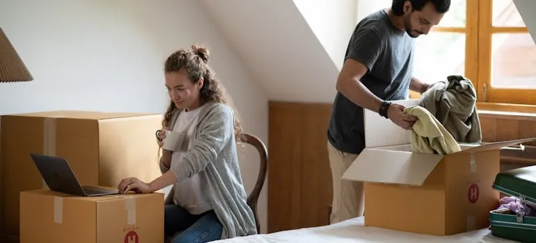 A couple packing and talking about temporary storage during a DMV move