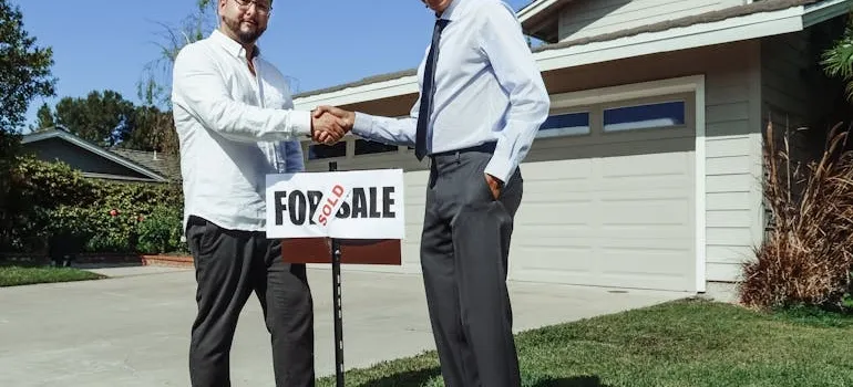 Two people shaking hands and talking about renting vs buying in Arlington