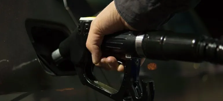 A person refilling gas in the car