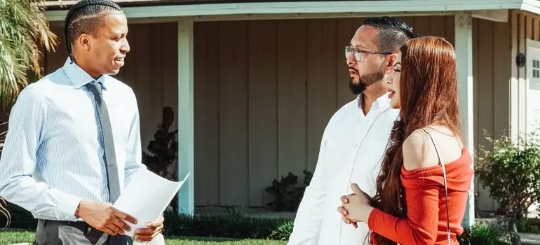 A couple talking with the real estate agent about Maryland vs Texas cost of living