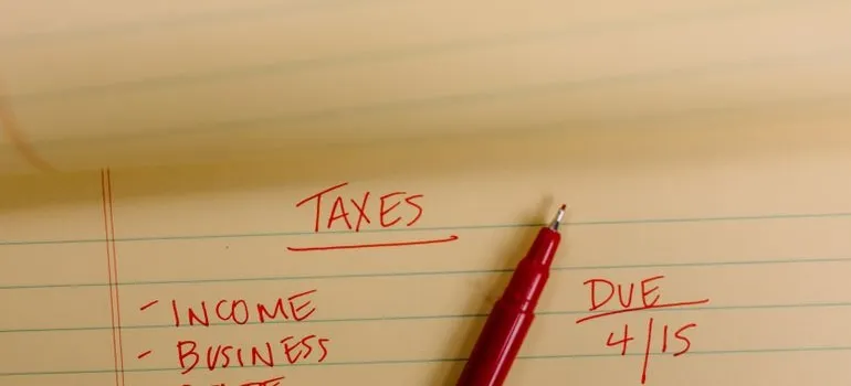 A person writing on the paper taxes that need to be paid